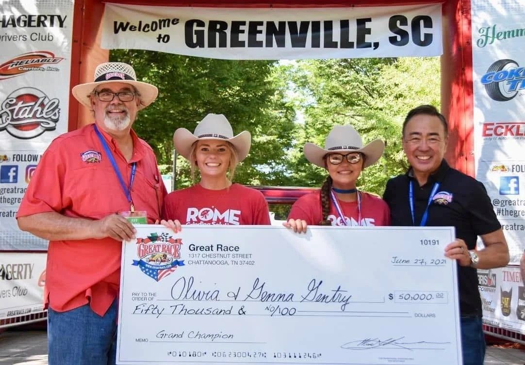 Olivia and Genna Gentry, 2021 Great Race Grand Champions, holding the $50,000 winner's check in Greenville, SC